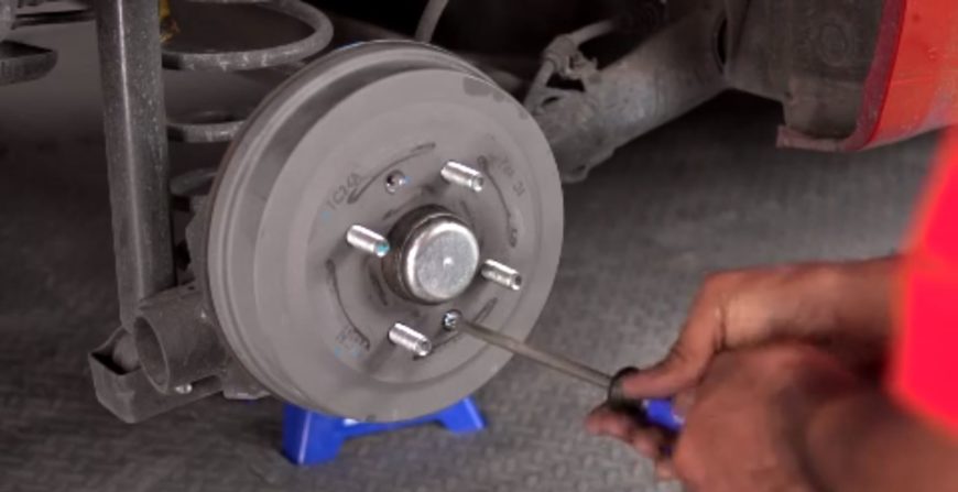A man showing how to change drum brakes.