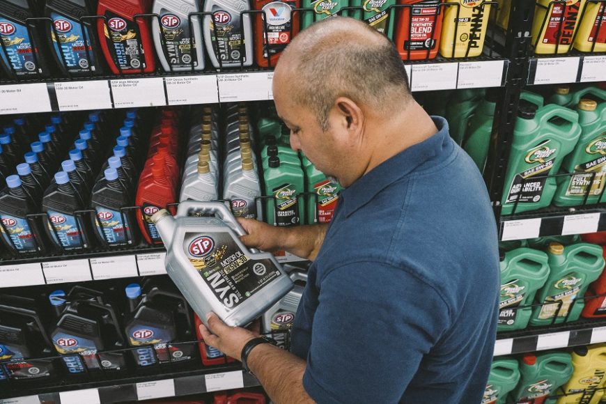 Man looking at STP 5W-30 synthetic motor oil at an AutoZone store.