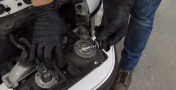 Removing a headlight bulb from a headlight casing placed on the fascia