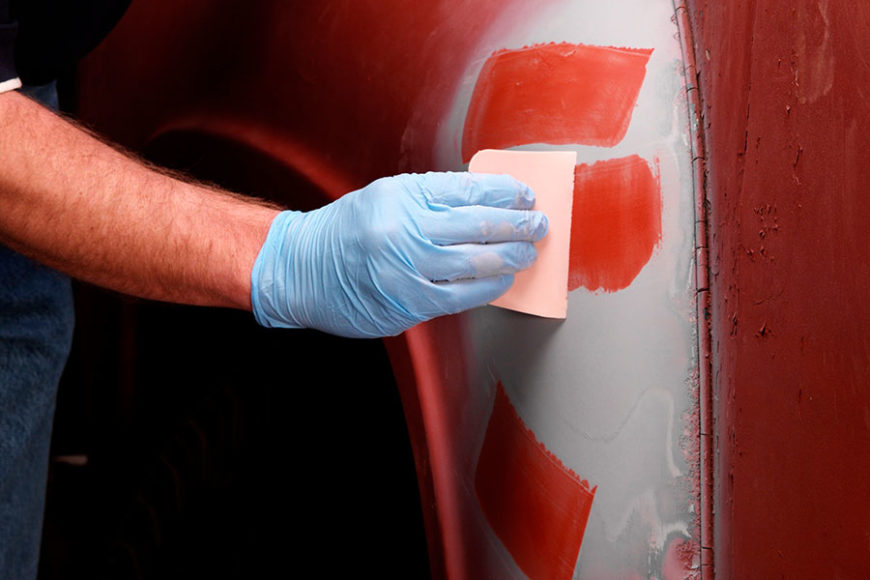 Person applying glaze to a dent that has been smoother over with body filler