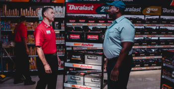 AutoZone store associate explaining the factors that affect battery life to a customer
