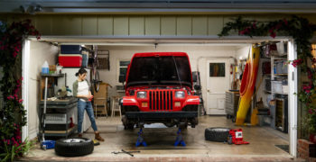 Woman getting ready to install new brakes on her jacked up JEEP Wrangler