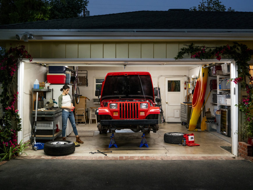 Woman getting ready to install new brakes on her jacked up JEEP Wrangler