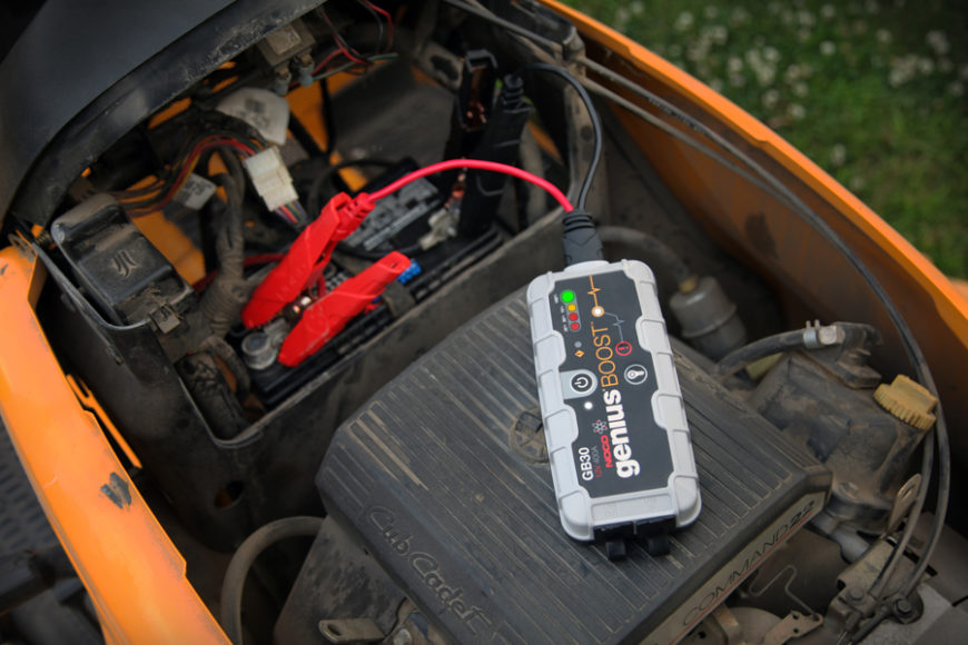 NOCO genius boost being used to show how to recharge a lawn mower battery