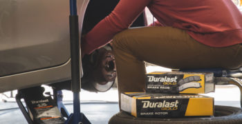 Man changing brakes so he can upgrade to Duralast Gold