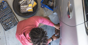 Man replacing old squeaky brakes with new Duralast Gold brake pads and rotors