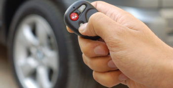 Person pointing a non-working key fob at a car and trying to get it to work