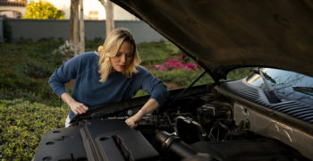 Woman preparing to replace a car battery.