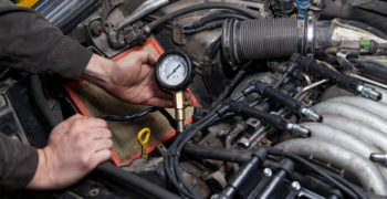 Person using a compression tester to diagnose engine problems