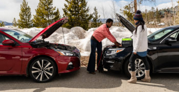 Essentials roadside emergency kit cars being jumped roadside in snow two women