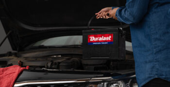 Duralast battery being installed in car by woman